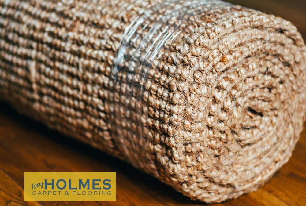 A roll of carpet sitting on a solid oak floor.