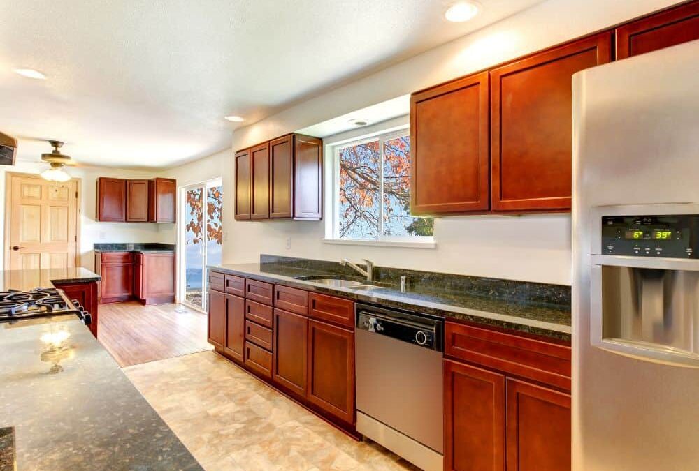 A kitchen with vinyl floors and cherry cabinets.